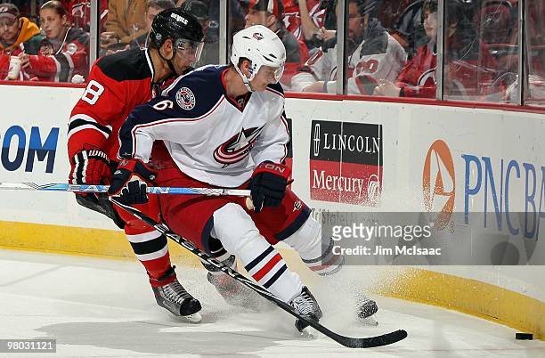 Anton Stralman of the Columbus Blue Jackets skates against Dainius Zubrus of the New Jersey Devils at the Prudential Center on March 23, 2010 in...