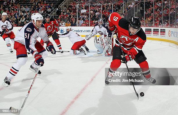 Zach Parise of the New Jersey Devils skates against Fedor Tyutin of the Columbus Blue Jackets at the Prudential Center on March 23, 2010 in Newark,...
