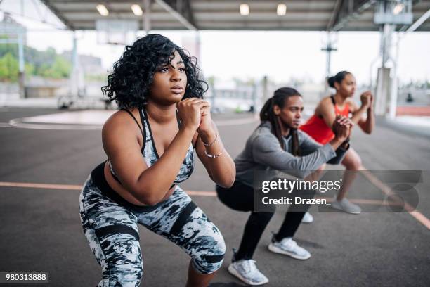 mulher obesa na sessão privada com instrutor feminino - squatting position - fotografias e filmes do acervo