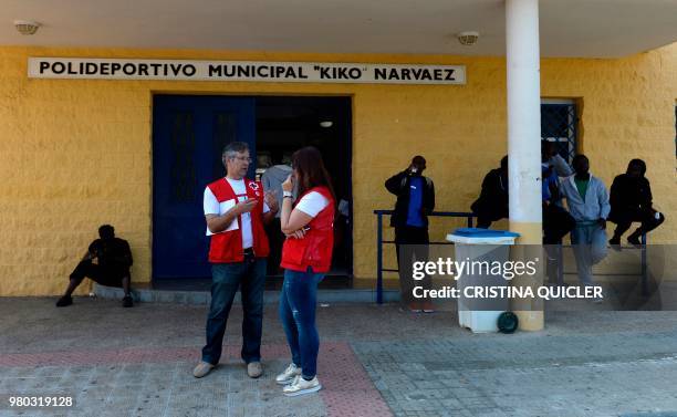 Red Cross members assist migrants outside a gymnasium used as reception center on June 21, 2018 in Jerez de la Frontera, southern Spain, where...