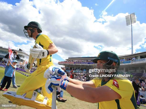 Australia's Aaron Finch and Australia's Travis Head take to the field to open batting on the fourth One Day International cricket match between...