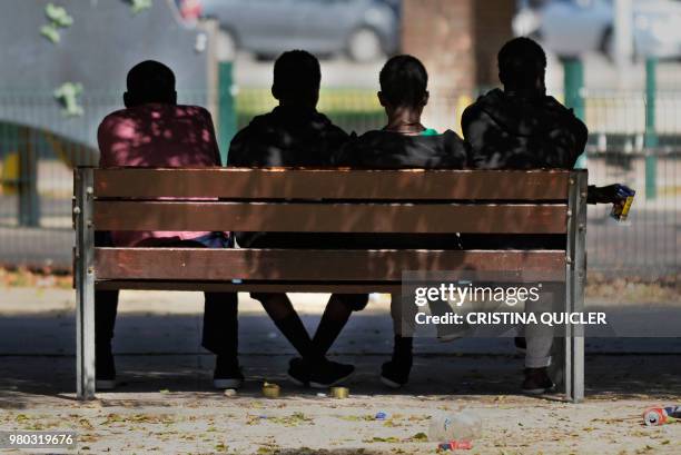 Migrants rest on a bench on June 21, 2018 at a park in Jerez de la Frontera, southern Spain, where hundreds of migrants have arrived bu boat in the...