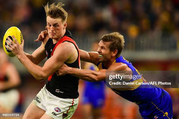 Matt Guelfi of the Bombers is tackled by Mark LeCras of the Eagles during the 2018 AFL round 14 match between the West Coast Eagles and the Essendon...