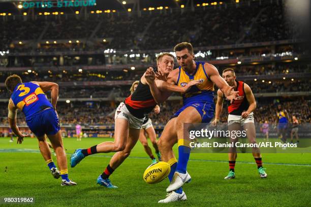 Fraser McInnes of the Eagles is bumped off the ball by Matt Guelfi of the Bombers during the 2018 AFL round 14 match between the West Coast Eagles...