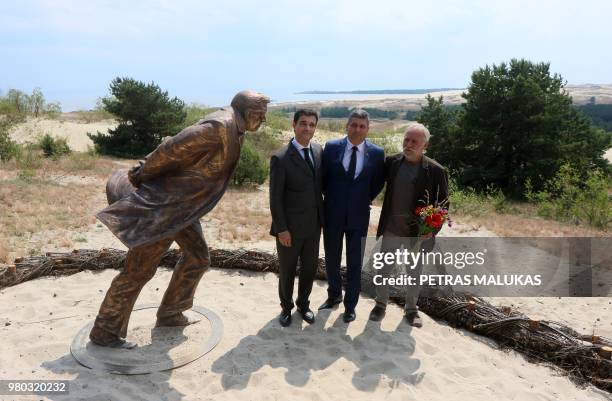 French Ambassador to Lithuania Philippe Jeantaud , sculptor Klaudijus Pudymas and the Mayor of Neringa Darius Jasiatis pose next to a bronze statue...