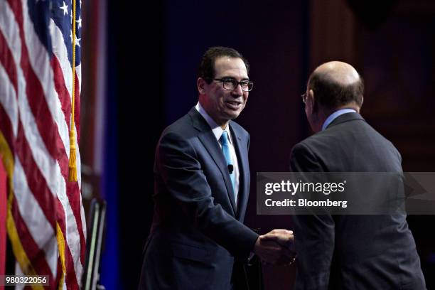 Steven Mnuchin, U.S. Treasury secretary, left, shakes hands with Wilbur Ross, U.S. Commerce secretary, while arriving to speak during the SelectUSA...