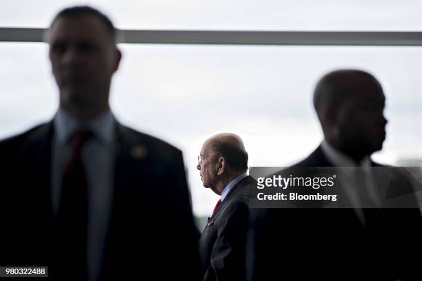 Security detail stands near Wilbur Ross, U.S. Commerce secretary, while speaking during a Bloomberg Television interview at the SelectUSA Investment...