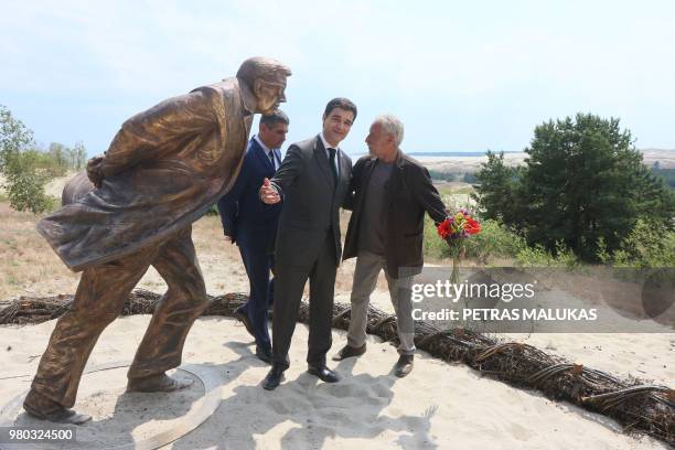 French Ambassador to Lithuania Philippe Jeantaud , sculptor Klaudijus Pudymas and the Mayor of Neringa Darius Jasiatis pose next to a bronze statue...