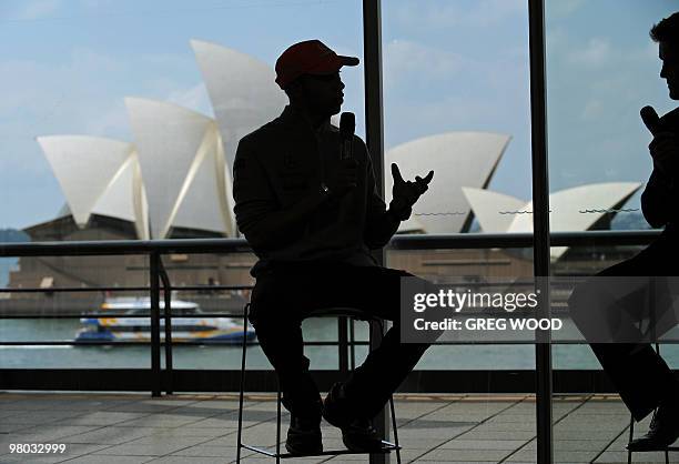 Formula One driver Lewis Hamilton answers a question, against a backdrop of the Sydney Opera House, during a press conference following a media photo...