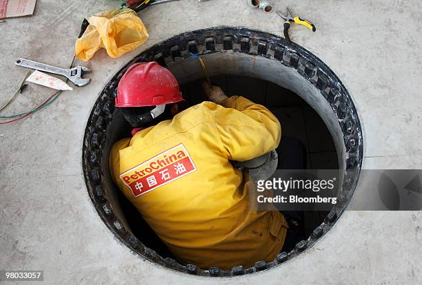 Worker refurbishes a PetroChina Co. Gas station in Shanghai, China, on Thursday, March 25, 2010. PetroChina Co., the world's biggest company by...