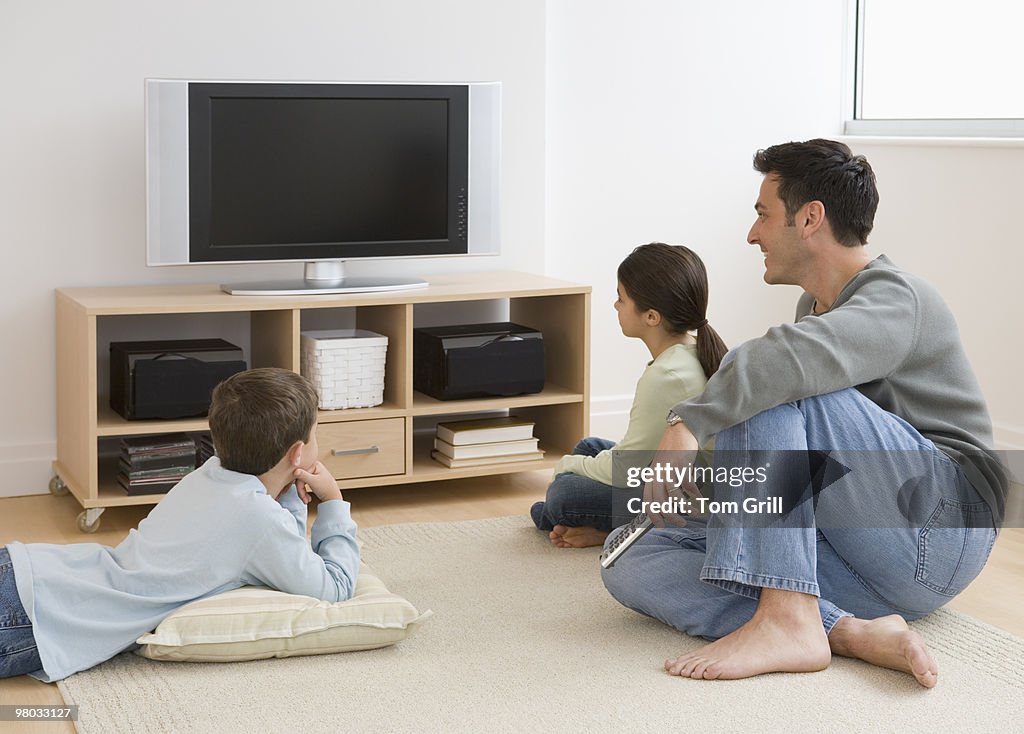 Father and children watching TV