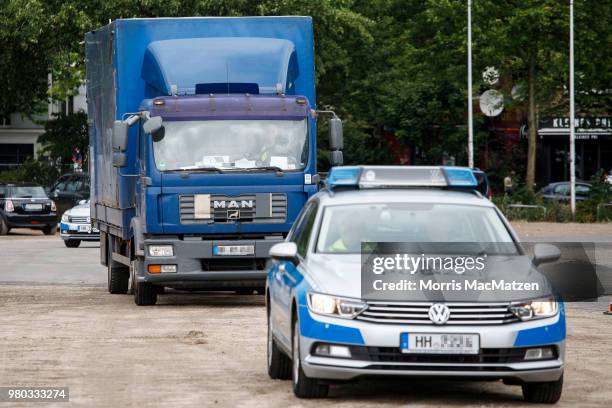 Police cars escort a truck that drove down Stresemannstrasse, a street where the city recently banned older model diesel trucks on June 21, 2018 in...