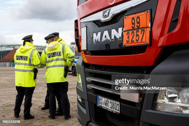 Police officers check the papers of a truck that drove down Stresemannstrasse, a street where the city recently banned older model diesel trucks on...