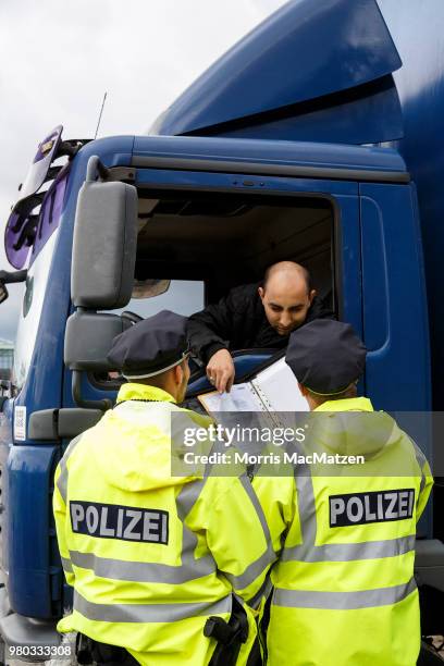 Police officers check the papers of a truck that drove down Stresemannstrasse, a street where the city recently banned older model diesel trucks on...