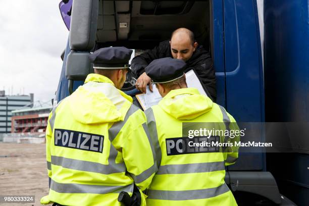 Police officers check the papers of a truck that drove down Stresemannstrasse, a street where the city recently banned older model diesel trucks on...