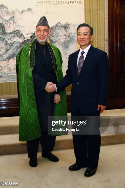 Chinese Premier Wen Jiabao shakes hand with Afghan President Hamid Karzai on March 25, 2010 in Beijing, China. Karzai is on a three day state visit...