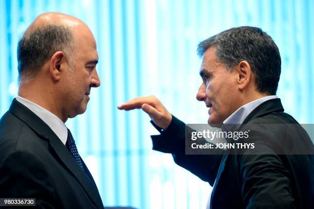 Commissioner of Economic and Financial Affairs, Taxation and Customs Pierre Moscovici talks with Greek Finance Minister Euclid Tsakalotos during a...