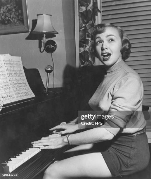 American actress, comedienne and singer Edie Adams accompanies herself on the piano at her home in Tenafly, New Jersey, circa 1950.