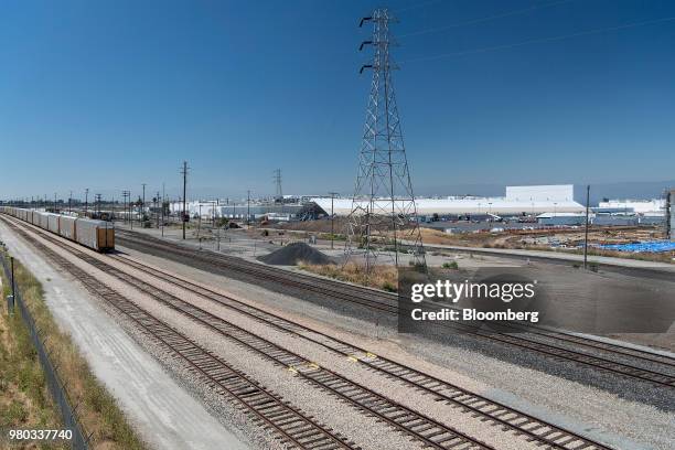 Train moves past a newly constructed production tent at the Tesla Inc. Manufacturing facility in Fremont, California, U.S., on Wednesday, June 20,...