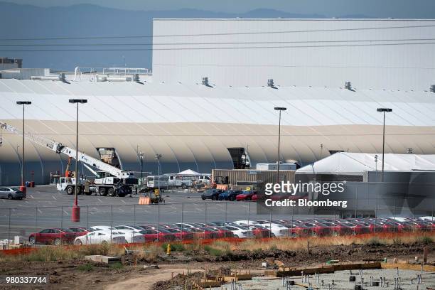Tesla Inc. Vehicles sit in a parking lot outside of a newly constructed production tent at the company's manufacturing facility in Fremont,...