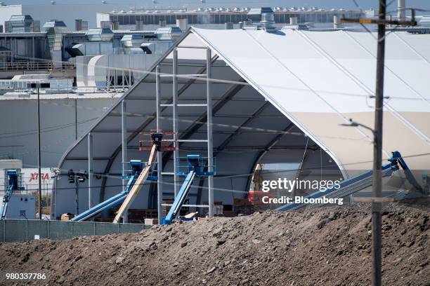 Cherry pickers stand outside a newly constructed production tent at the Tesla Inc. Manufacturing facility in Fremont, California, U.S., on Wednesday,...