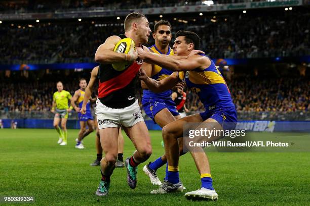 Devon Smith of the Bombers fends off Tom Cole of the Eagles during the round 14 AFL match between the West Coast Eagles and the Essendon Bombers at...