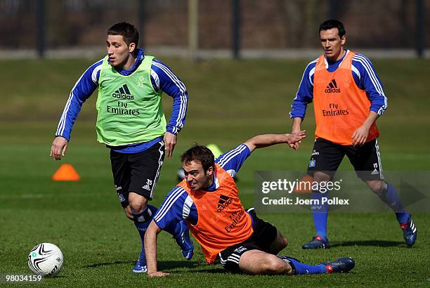 Tunay Torun and Joris Mathijsen of Hamburg compete for the ball during the Hamburger SV training session at the HSH Nordbank Arena on March 25, 2010...