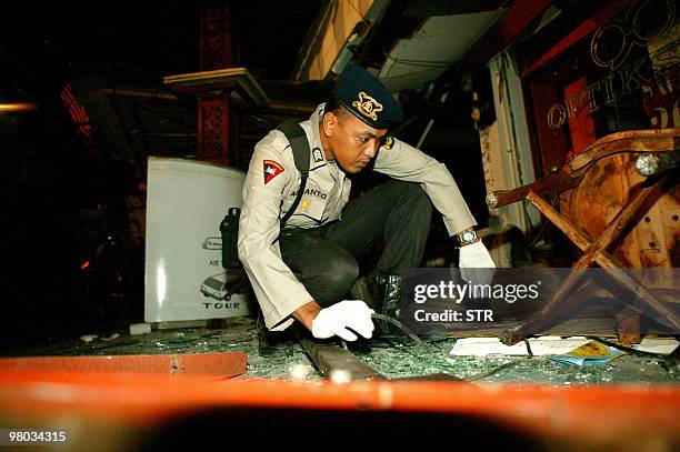 An Indonesian policeman surveys the scene at a bomb damaged resteraunt in Kuta, on the island of Bali, 01 October 2005. At least 23 people were...