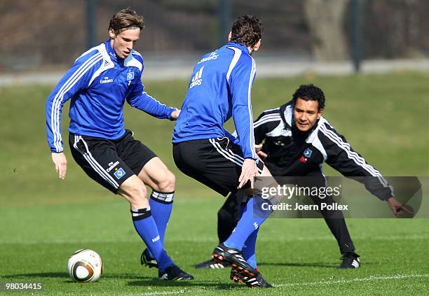 Marcell Jansen and Bastian Reinhardt of Hamburg compete for the ball while assistent trainer Ricardo Moniz issues instructions during the Hamburger...