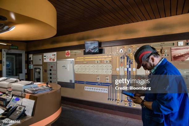 Worker uses a smartphone in the grain silo control room at the Lecureur SA cereal plant in the Port of Rouen, in Val de la Haye, France, on Thursday,...