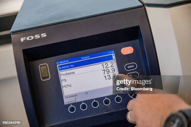 Worker uses a grain analyser, manufactured by Foss Analytical A/S, during protein and humidity checks at the Lecureur SA cereal plant in the Port of...