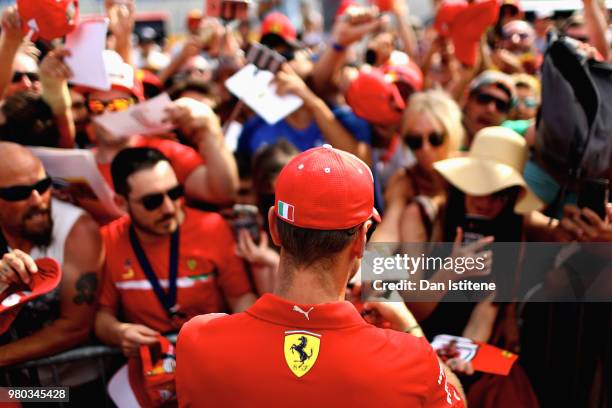 Sebastian Vettel of Germany and Ferrari signs autographs for fans in the Pitlane during previews ahead of the Formula One Grand Prix of France at...