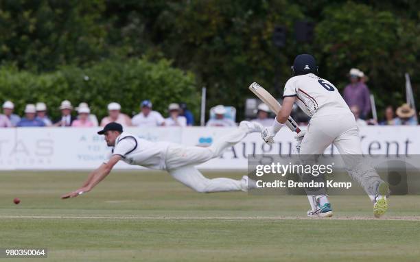 Joe Denly of Kent places the ball past the diving fielder on day two of the Specsavers County Championship: Division Two match between Kent and...