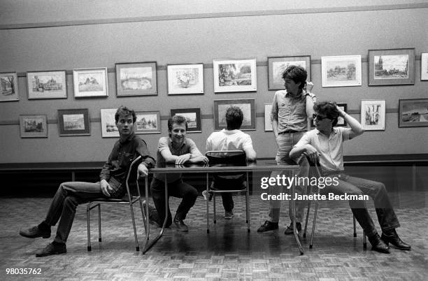 Portrait of British new wave group Interview as they sit around a table, England, 1979. The band consisted of singer Jeff Starrs, bassist Phil...