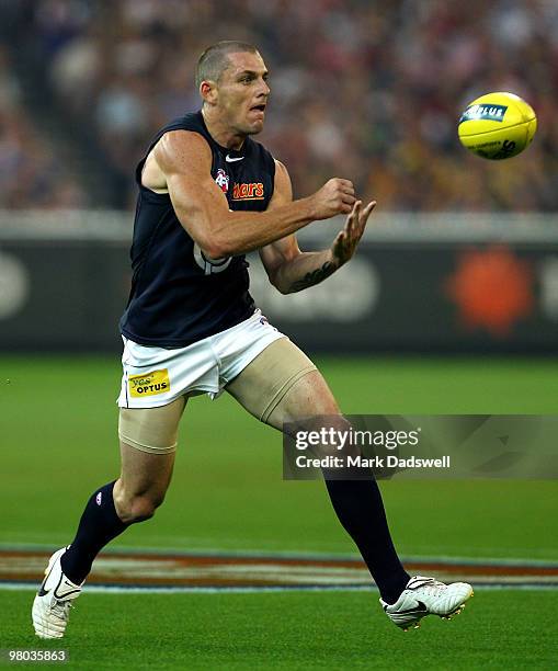 Heath Scotland of the Blues handballs during the round one AFL match between the Richmond Tigers and Carlton Blues at Melbourne Cricket Ground on...