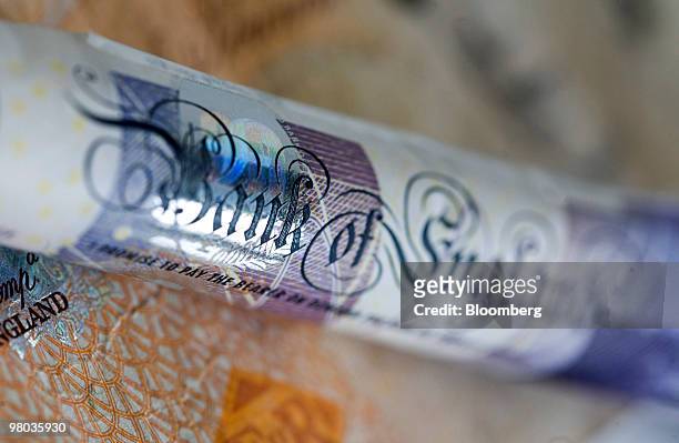 Twenty pound note and ten pound note sit arranged for a photograph in London, U.K., on Thursday, March 25, 2010. The pound had its biggest gain in...