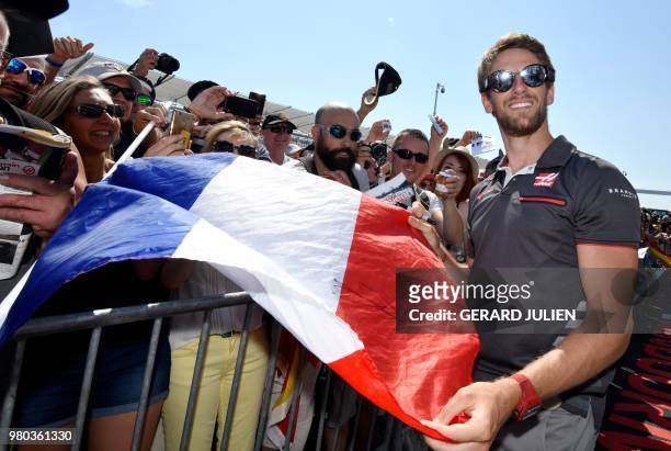 Haas F1's French driver Romain Grosjean poses with a French flag and fans at the Circuit Paul Ricard in Le Castellet, southern France, on June 21 a...