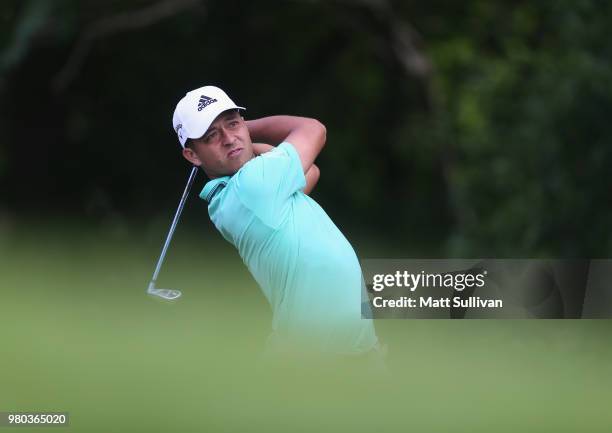Xander Schauffele watches his tee shot on the 12th hole during the first round of the Travelers Championship at TPC River Highlands on June 21, 2018...