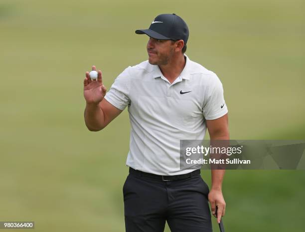 Brooks Koepka waves to the gallery after making a birdie on the 12th hole during the first round of the Travelers Championship at TPC River Highlands...