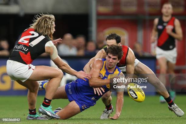 Andrew Gaff of the Eagles gets his handball away while being tackled during the round 14 AFL match between the West Coast Eagles and the Essendon...