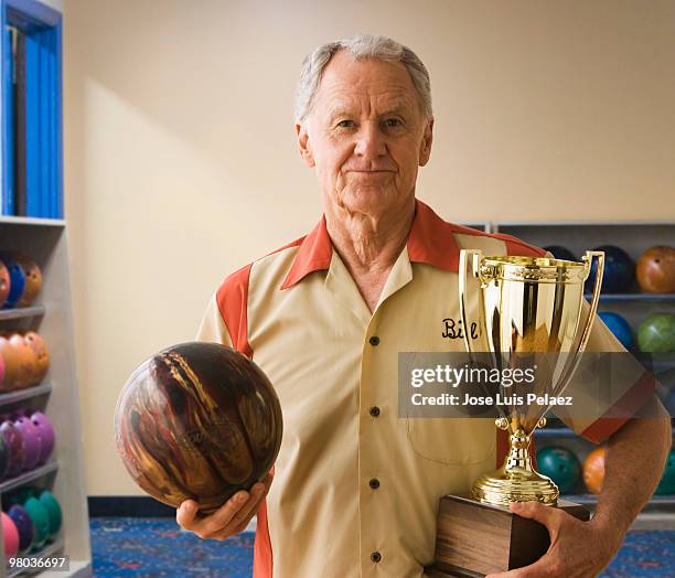 senior man holding bowling ball and trophy - man holding bowling ball stock pictures, royalty-free photos & images