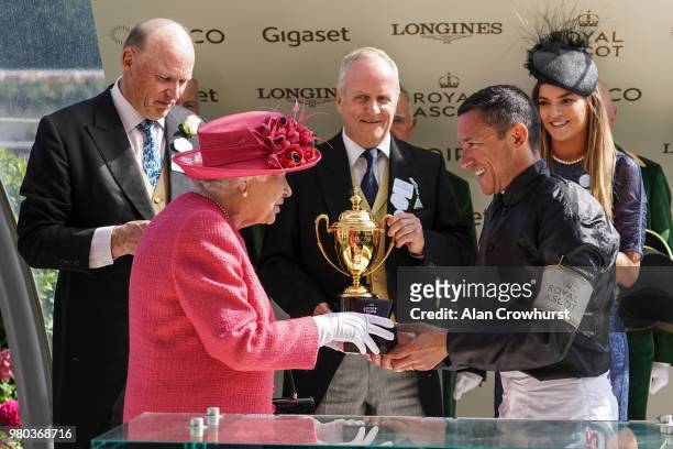 Queen Elizabeth II presents Frankie Dettori with his prize after he rode Stradivarius to win The Gold Cup on day 3 of Royal Ascot at Ascot Racecourse...