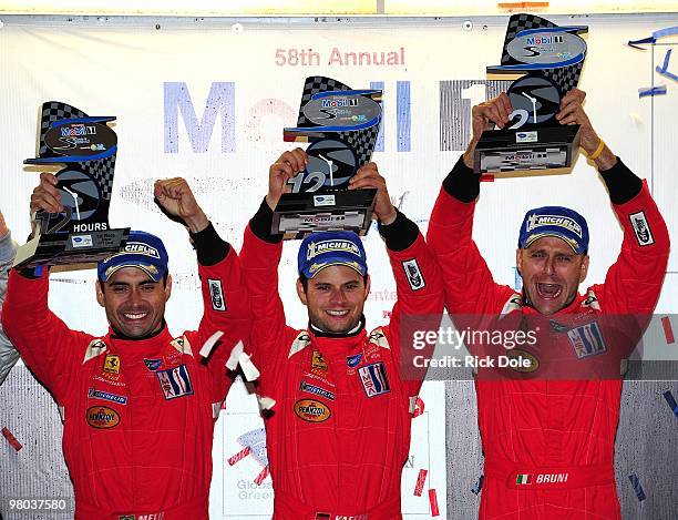 Jamie Melo, Pierre Kaffer, and Gianmaria Bruni celebrate on the podium after winning the GT2 class driving the Risi Competizione Ferrari 430 GT...