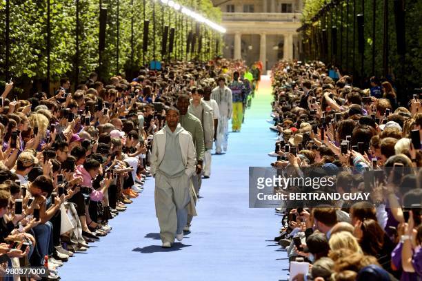 Models present creations by Louis Vuitton at the end of the men's Spring/Summer 2019 collection fashion show on June 21, 2018 in Paris.