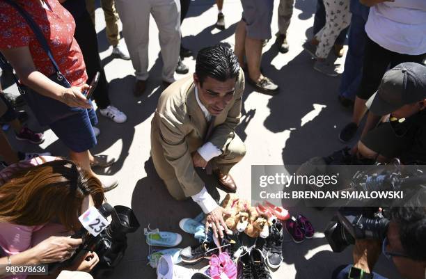 Miami mayor Francis Suarez looks at shoes left by people at the Tornillo Port of Entry near El Paso, Texas, June 21, 2018 during a protest rally by...