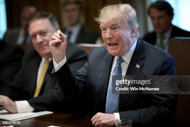 President Donald Trump speaks while holding up a pen he said he would use to sign immigration legislation during a cabinet meeting at the White House...