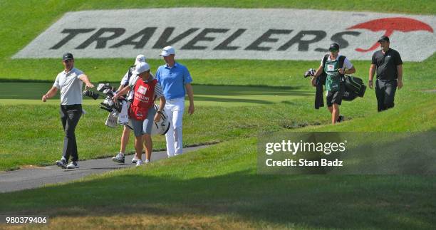 Brooks Koepka, Webb Simpson and Patrick Reed approach the 15th green during the first round of the Travelers Championship at TPC River Highlands on...