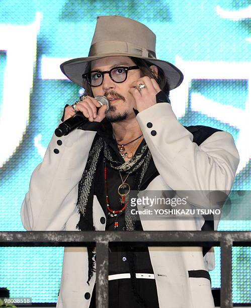 Actor Johnny Depp waves to Japanese fans upon his arrival at the Japan premiere of their latest movie 'Alice in Wonderland' in Tokyo on March 22,...