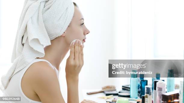 quitar el maquillaje de su rostro joven - acolchado deportivo fotografías e imágenes de stock