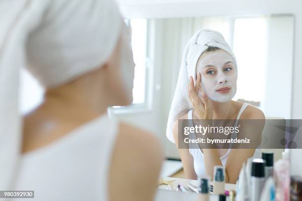 frau mit einer maske im gesicht - maske stock-fotos und bilder